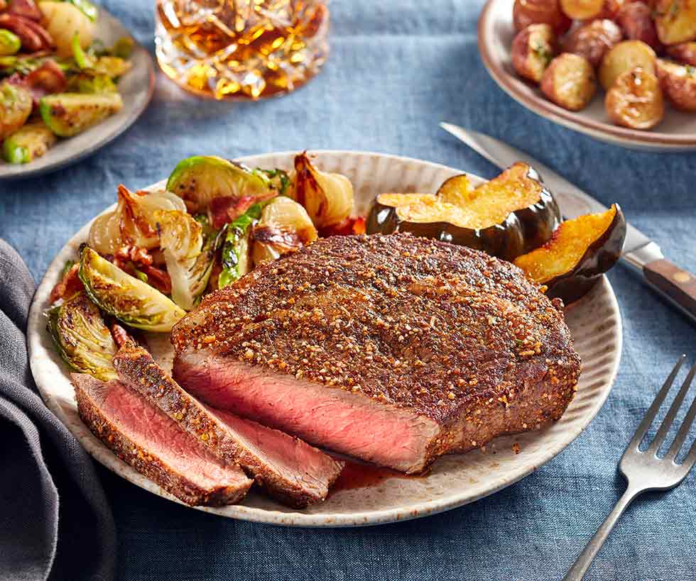 Seasoned medium-rare steak prepared with Brussels sprouts