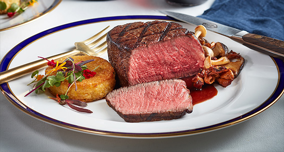 Cooked and plated filet mignon with grill marks that is red and juicy