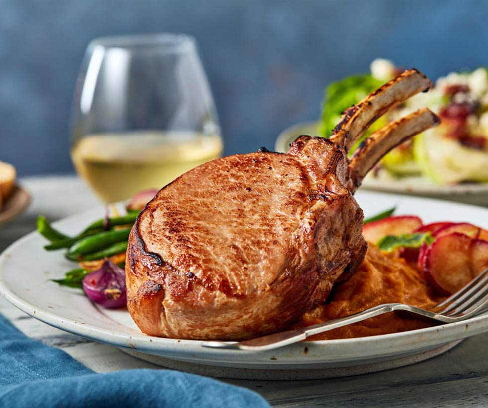 Baked pork chop served on a plate with fresh vegetables