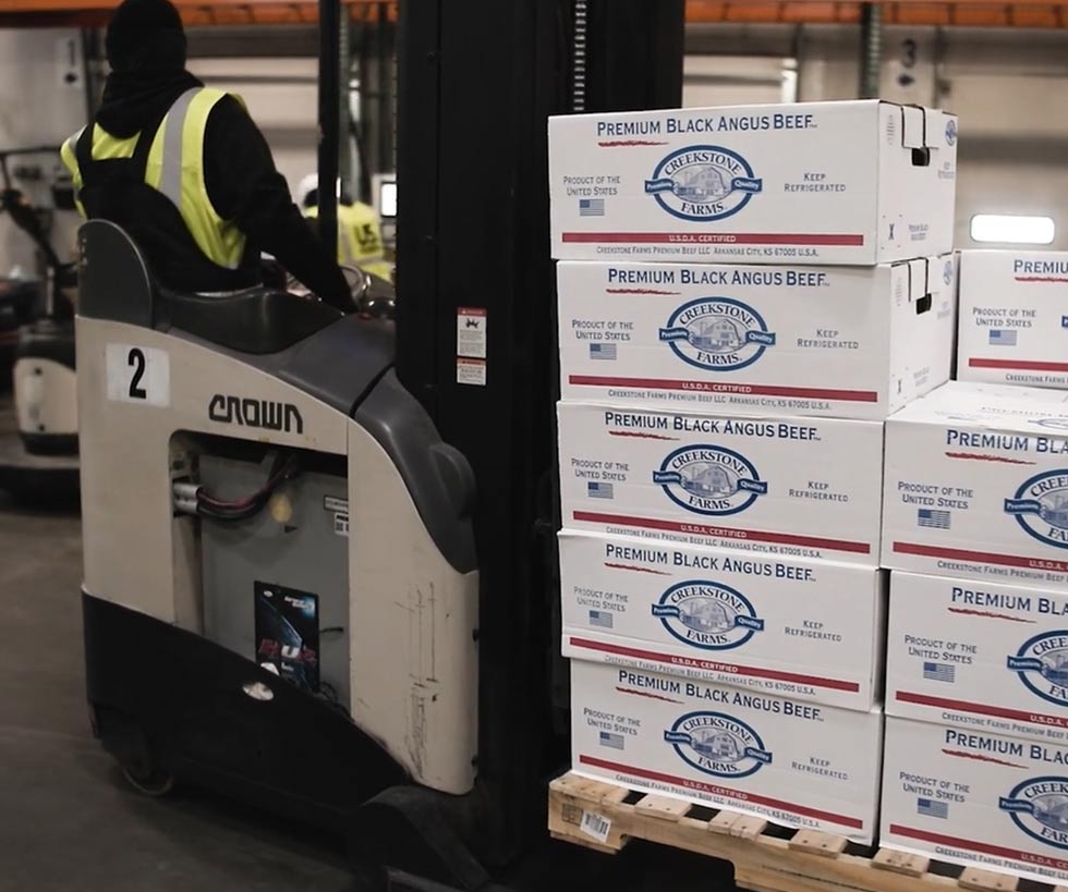 Boxes of Creekstone Farms premium Black Angus beef on a pallet being moved by a forklift