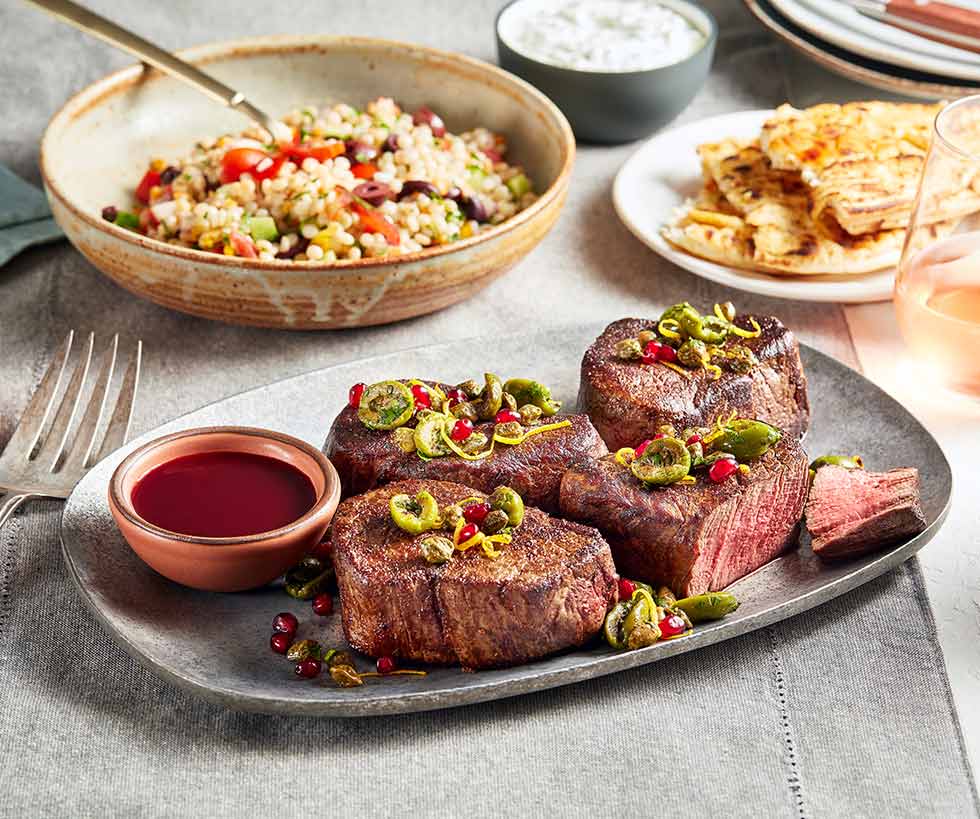 Four Mediterranean style filet mignon prepared with a side of rice